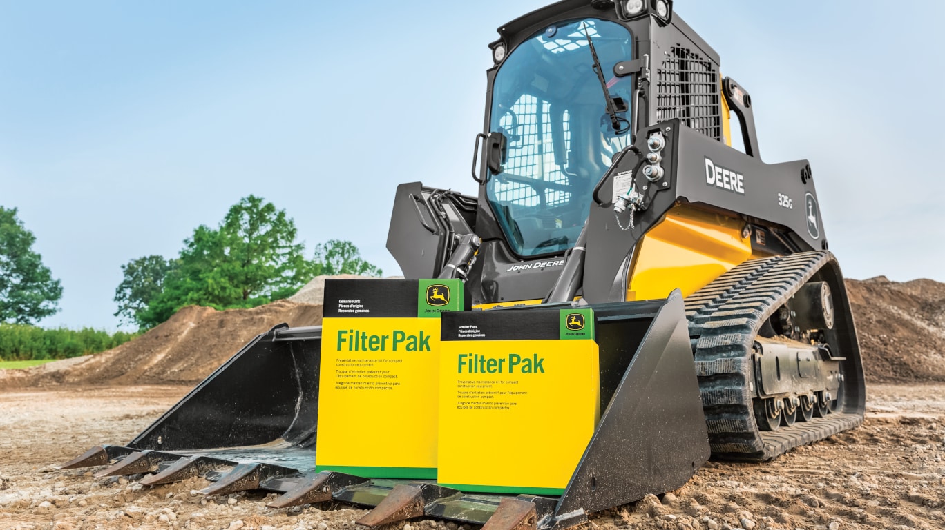 John Deere filter pak displayed in a bucket of a John Deere skid steer